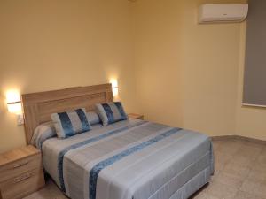1 dormitorio con 1 cama grande con almohadas azules en Hotel Novo, en Ponferrada
