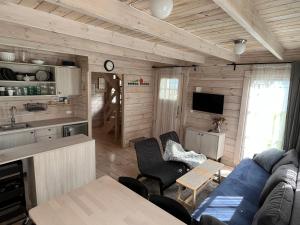 een woonkamer met een blauwe bank en een keuken bij Domki w Porcie Genaker in Giżycko