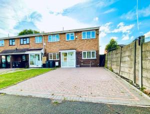 una casa de ladrillo con una puerta blanca y una valla en Mayfair Place - Cosy 3 Bedroom House with Free Parking, en Birmingham