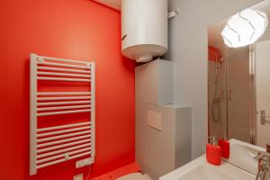 a bathroom with red walls and a white sink at HONORÊ SUITE FERRANDIERE in Lyon