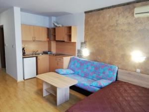 スヴェティ・ヴラスにあるLovely Studio in a Complex with a Pool by Flat Mаnаgerの青いソファとテーブルのあるリビングルーム