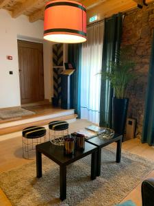 a living room with a coffee table and two stools at Largo da Rainha, Guesthouse in Merciana