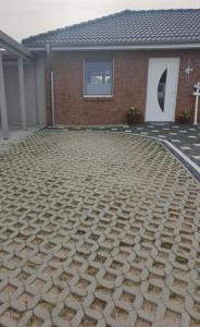 a house with a stone driveway in front of it at Ferienwohnung Völkner in Hamdorf