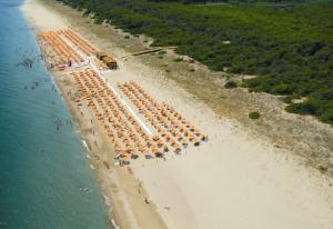 eine Luftansicht auf einen Strand mit Sonnenschirmen in der Unterkunft Casa Marinella al confine fra Basilicata e Puglia in Bernalda