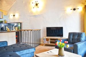 ein Wohnzimmer mit einem Sofa und einem TV in der Unterkunft Haus8 – dein Genussferienhaus in Mettlach