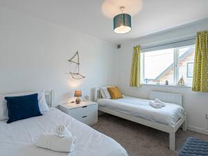 a bedroom with two beds and a window at Pass the Keys Sea View Apartment in centre of Rhosneigr in Rhosneigr