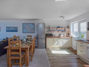 una cocina y comedor con una mesa y un refrigerador en Sea View Apartment in centre of Rhosneigr - Pass the Keys, en Rhosneigr
