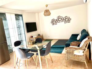 a living room with a couch and a table and chairs at Cabanas Wonder - 150mts from the beach in Cabanas de Tavira