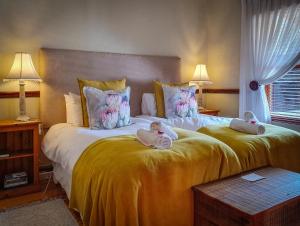 Oudtshoorn的住宿－伯爾路達農莊及小屋酒店，两个婴儿坐在卧室的两张床上