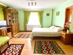 1 dormitorio con cama, ventana y alfombra en Casa Agroturistica Tarancuta din Vatra Moldovitei, en Vatra Moldoviţei