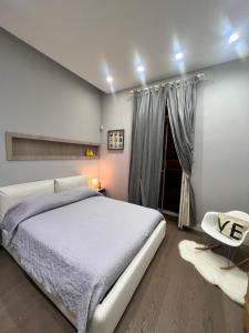 sypialnia z białym łóżkiem i białym krzesłem w obiekcie RaRoom Boutique Home w mieście Torre del Greco
