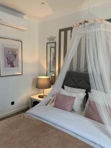 a bedroom with a canopy bed with pink pillows at Largo da Rainha, Guesthouse in Merciana