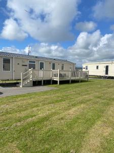 a mobile home with a porch and a deck at Cosy caravan in Hull