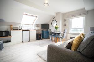 a living room with a couch and a table and a kitchen at Sperrin View Suite - Luxury space with Budget Friendly pricing in Maghera