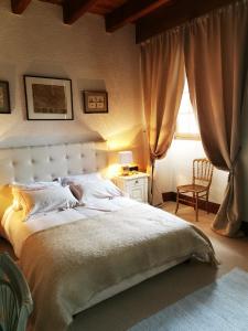 ein Schlafzimmer mit einem Bett, einem Stuhl und einem Fenster in der Unterkunft maison de campagne in Isômes