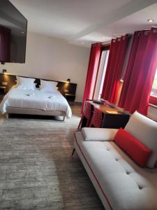 a hotel room with a bed and a couch at Hôtel Restaurant Les Alizés in Lipsheim