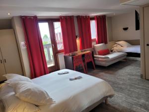 una habitación de hotel con una cama grande y cortinas rojas en Hôtel Restaurant Les Alizés, en Lipsheim