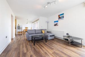 uma sala de estar com um sofá e uma mesa em ALTIDO Modern 2 bed flat near Inverleith Park, with terrace and free parking em Edimburgo