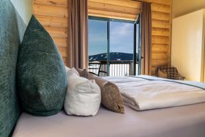 ein Schlafzimmer mit einem Bett mit Kissen und einem Fenster in der Unterkunft Hotel Jens Weissflog in Kurort Oberwiesenthal