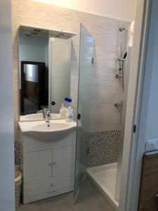 uma casa de banho com um lavatório e um chuveiro com um espelho. em Casa Mia em Verona