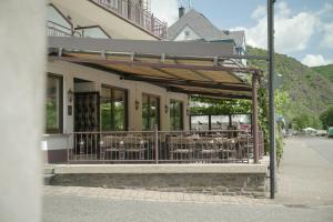 ein Restaurant mit Tischen und Stühlen an der Seite eines Gebäudes in der Unterkunft Ley Hotel in Klotten