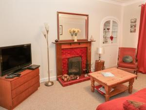 a living room with a fireplace and a tv at 32 High Street in Burntisland