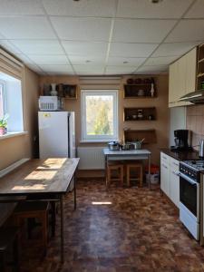 a kitchen with a table and a refrigerator at Smilgas in Riga