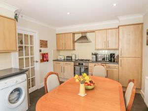 a kitchen with a wooden table with a vase of flowers on it at 32 High Street in Burntisland