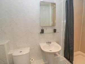 a white bathroom with a toilet and a sink at Cheviot Hills in Wooler +33 photos