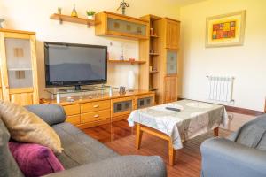 uma sala de estar com uma televisão e uma mesa em Apartamento Ultreia em Palas de Rei 