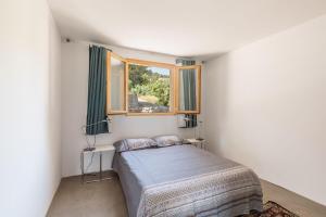 Schlafzimmer mit einem Bett und einem Fenster in der Unterkunft La casa alta in Sagunt
