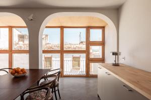 a kitchen with a table and chairs and some windows at La casa alta in Sagunto