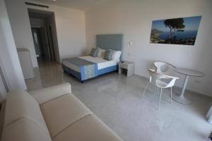 uma sala de estar com um sofá e uma cama em Hotel Lucia em Castellammare di Stabia