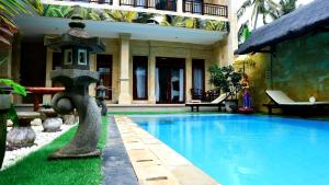 a swimming pool with a bird house next to a building at Bali 85 Beach Inn in Padangbai