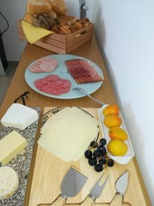 a table with a cutting board with cheese and other foods at B&B O Pescador in Nazaré