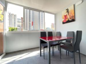 jadalnia z czerwonym stołem i czarnymi krzesłami w obiekcie New Square Ocean w mieście Benidorm
