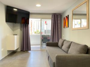 salon z kanapą i telewizorem w obiekcie New Square Ocean w mieście Benidorm