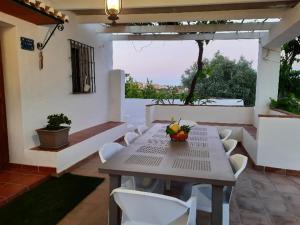 a patio with a table and white chairs and a window at FINCA VALENZUELA in Mijas