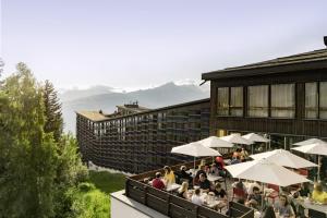 a group of people sitting outside of a building at Belambra Clubs Arc 1800 - Hôtel Du Golf in Arc 1800