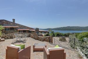 a house with a patio with a table and chairs at VILLA MARIA - CAPO D'ORSO - HOME and MORE in Palau