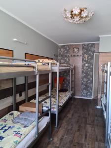 a room with three bunk beds and a chandelier at Smilgas in Riga