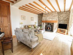 a living room with a couch and a fireplace at Ystrad Bach in Denbigh