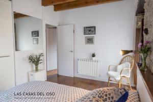 ein Schlafzimmer mit einem Bett und einem Stuhl in der Unterkunft El Torreón - Las Casas del Oso in Proaza