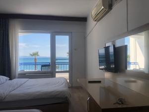 a bedroom with a bed and a view of the ocean at Ozsoy Hotel in Akçay