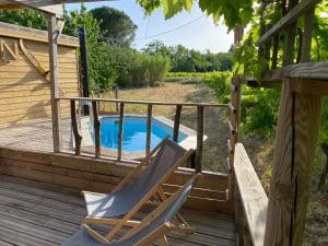 una terraza con una silla y una piscina en Roulotte du Moulin Saint Valentin en Roquemaure