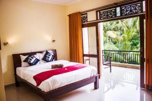 Schlafzimmer mit einem Bett und einer Glasschiebetür in der Unterkunft Bali 85 Beach Inn in Padangbai
