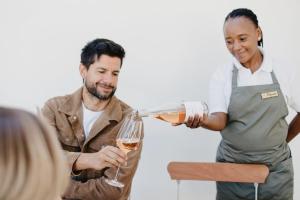 a man pouring a glass of wine for a woman at Weltevreden Estate in Stellenbosch