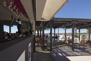 een restaurant met uitzicht op het water met tafels en stoelen bij Belambra Clubs Balaruc-les-Bains - Les Rives De Thau in Balaruc-les-Bains