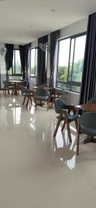 una stanza con tavoli, sedie e finestre di Thanh Thu 1 Hotel a Kon Tum (2)