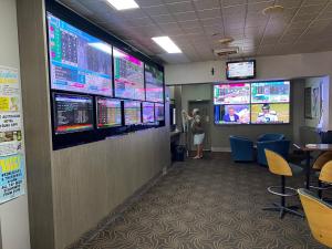 una persona de pie en una sala de comercio con monitores en la pared en Australian Hotel Young, en Young